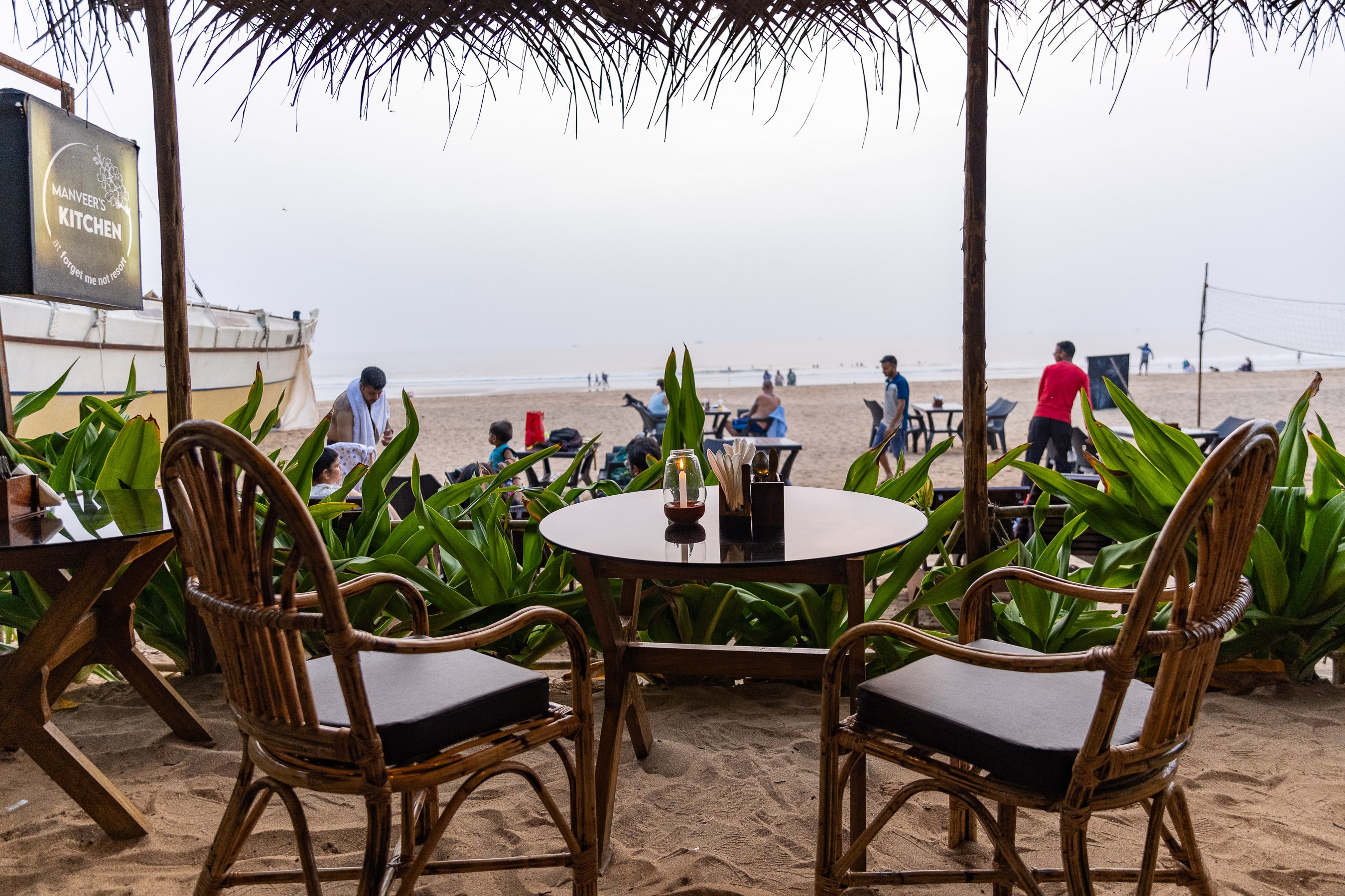 Manveer's Kitchen beachfront dining with rattan chairs and candle, Agonda